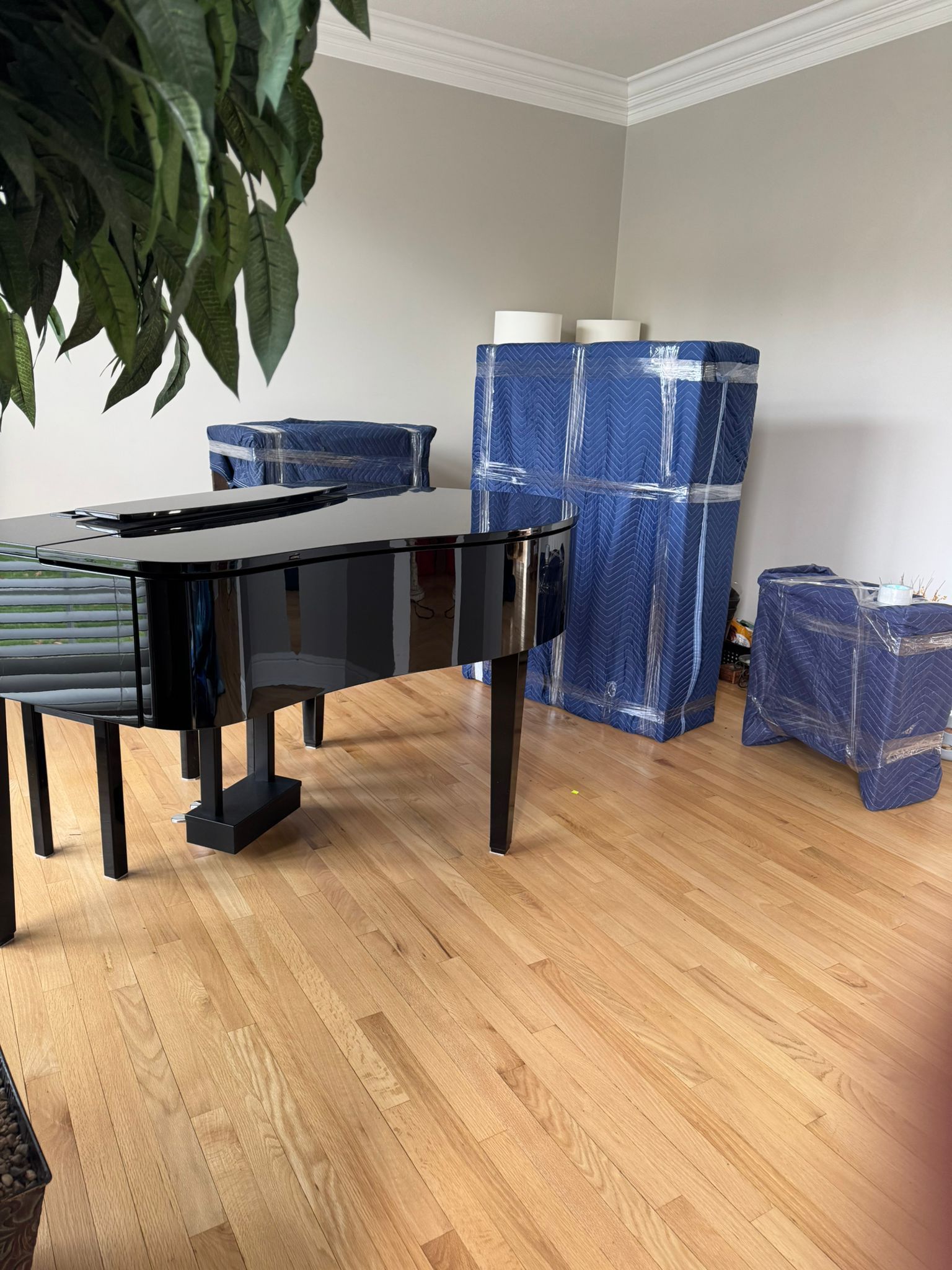 A man is pushing a large piece of furniture on a cart