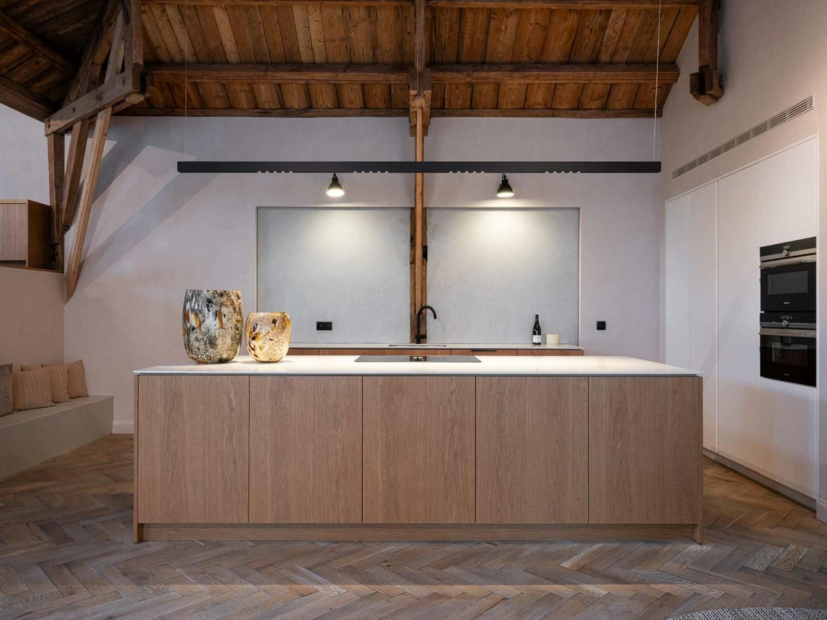 Een keuken met houten kasten en een wit aanrechtblad