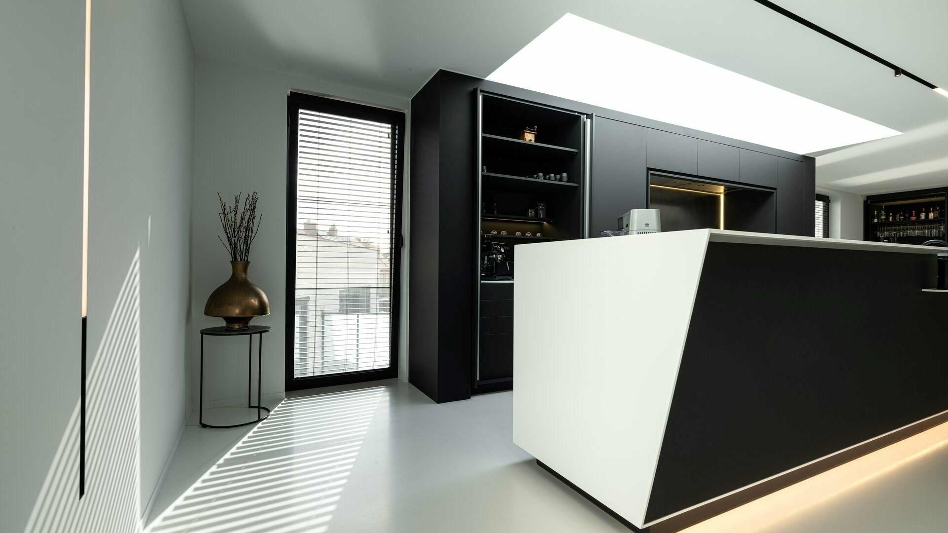 Een zwart-witte keuken met een groot eiland in het midden