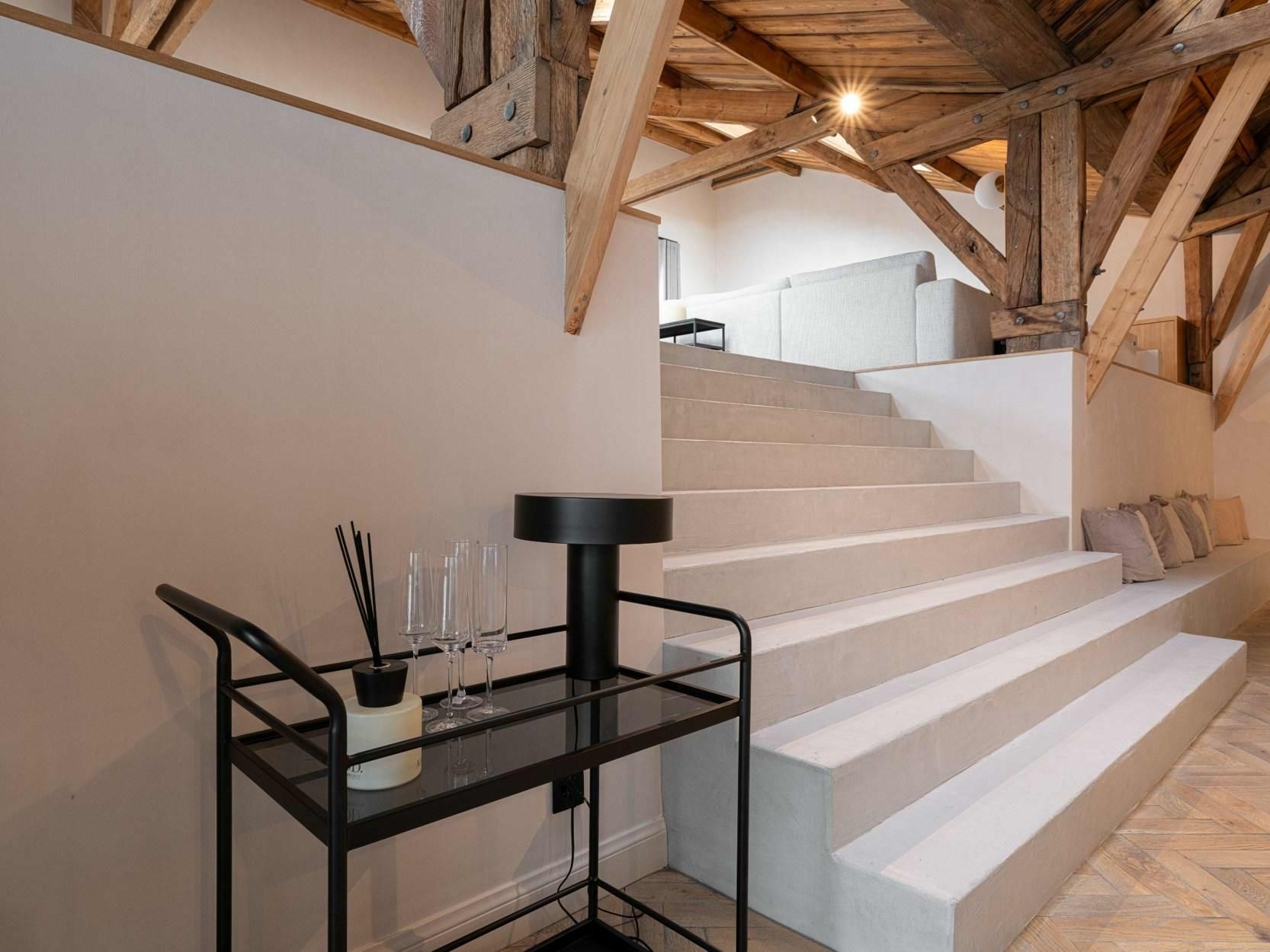 Een eetkamer met een lange witte tafel en zwarte stoelen.