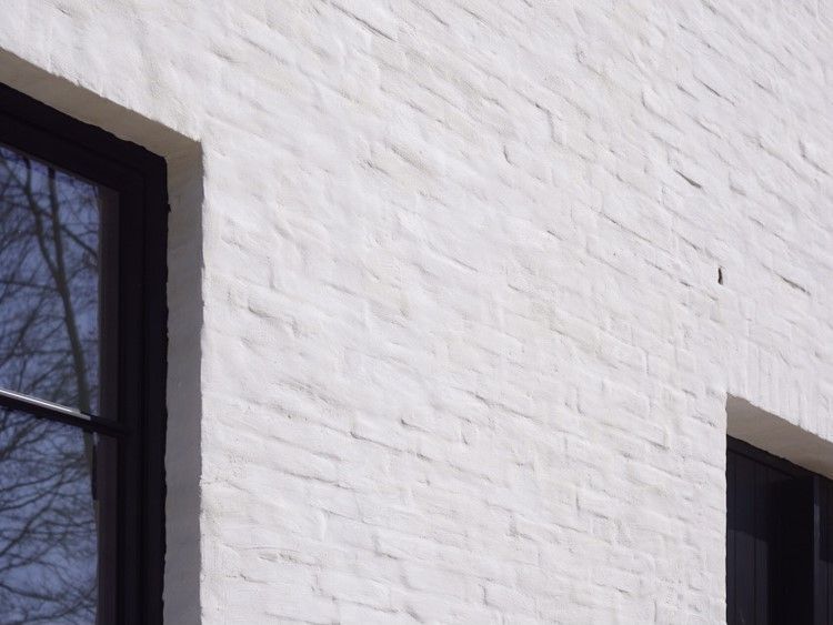 Een close-up van een wit bakstenen gebouw met zwarte ramen