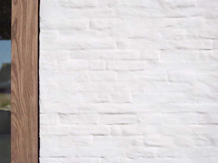 Een close-up van een witte bakstenen muur met een houten frame.