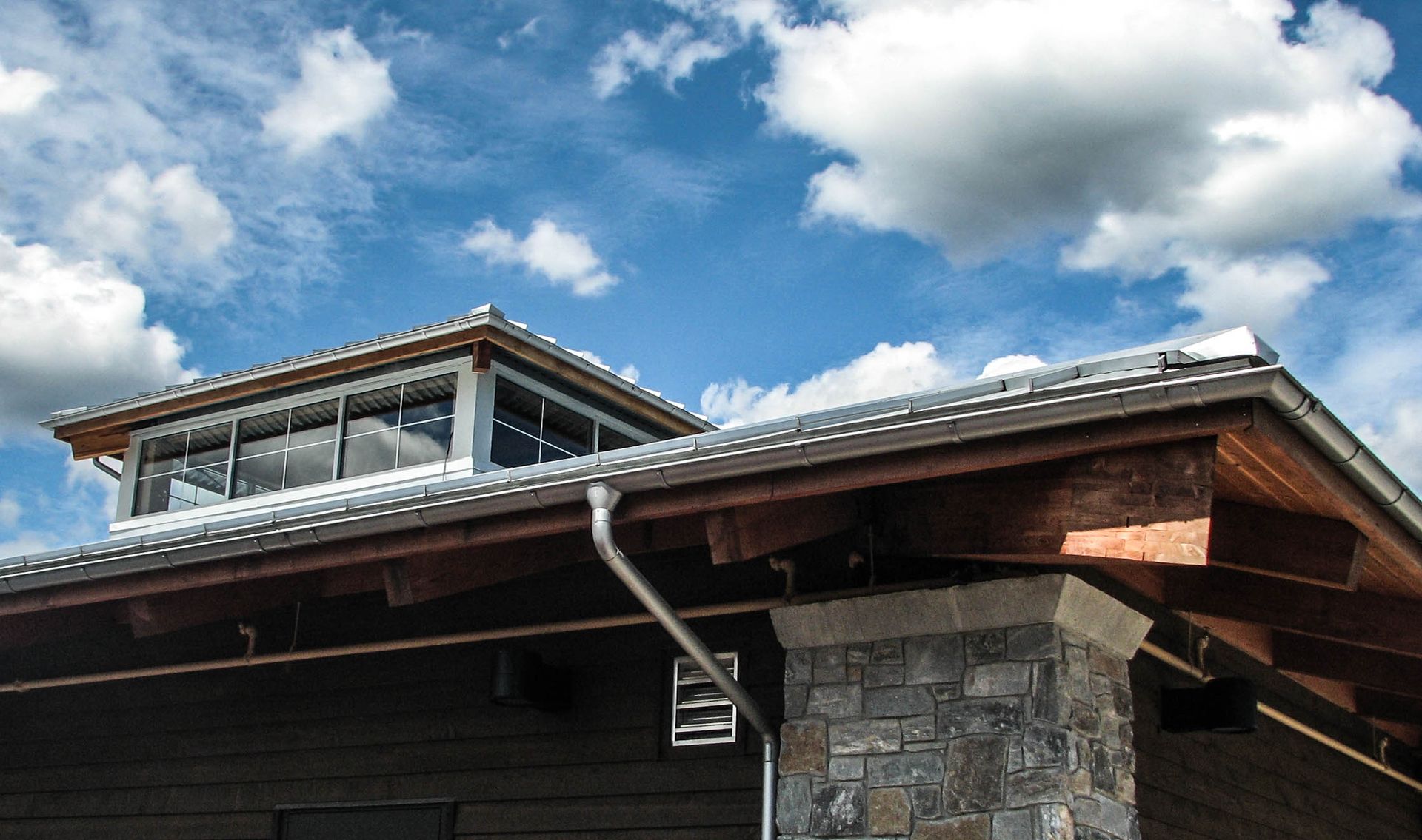 The roof of a house with a blue sky in the background