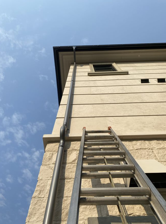 A ladder is sitting on the side of a building.