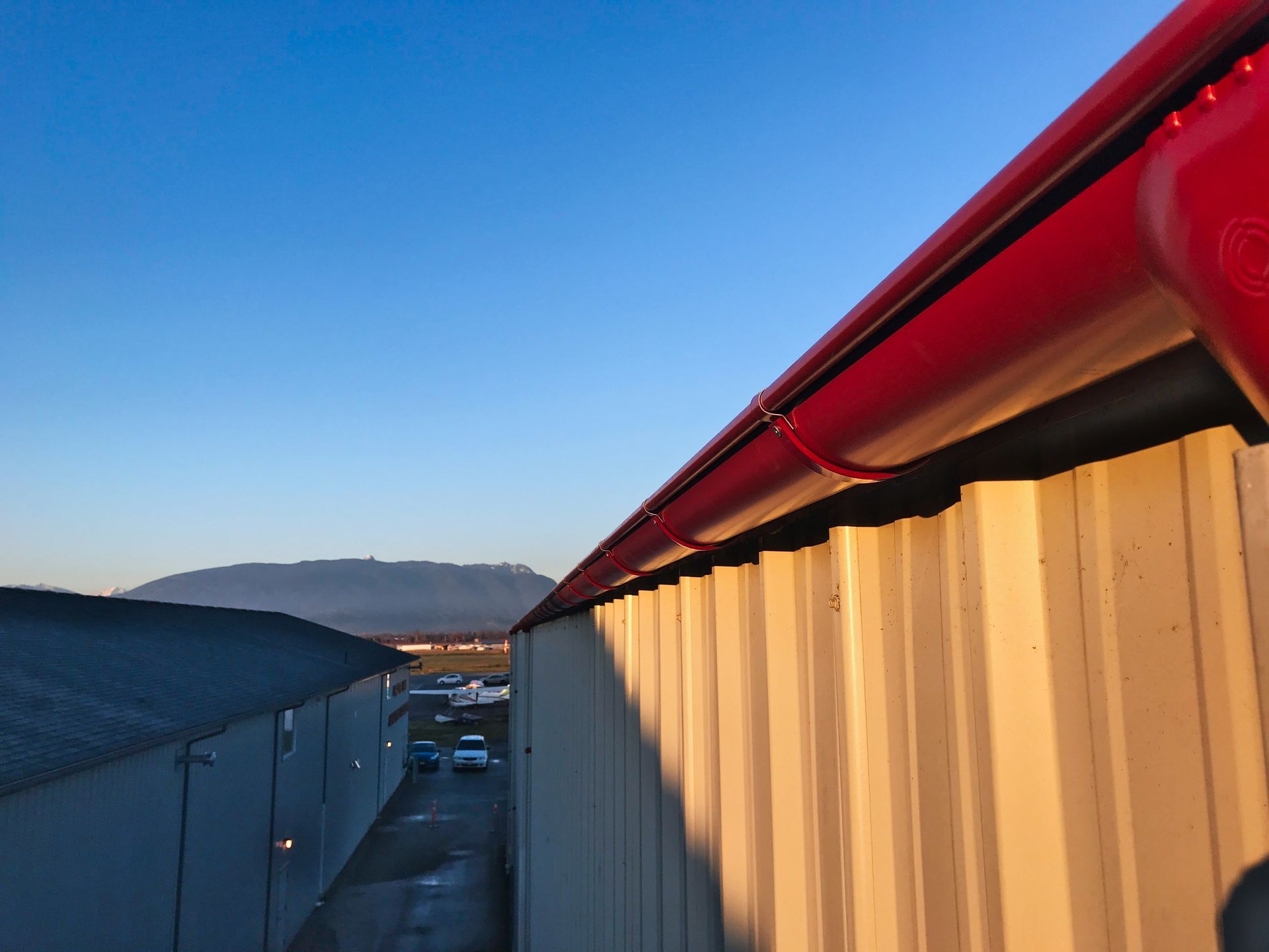 A red gutter is on the side of a building