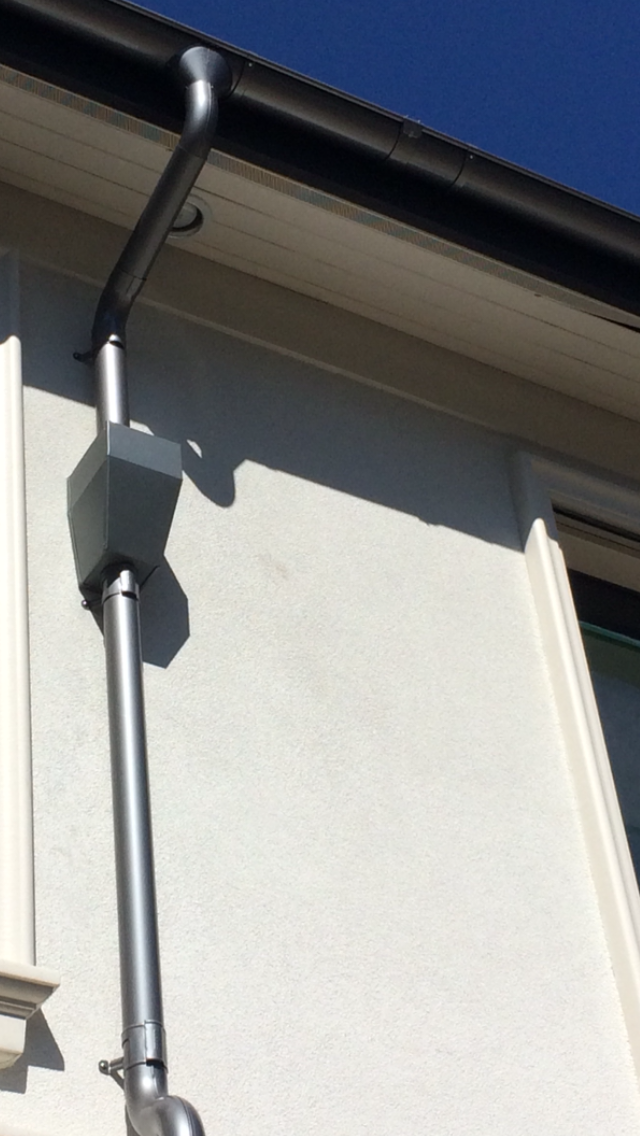 A close up of a gutter on the side of a building.
