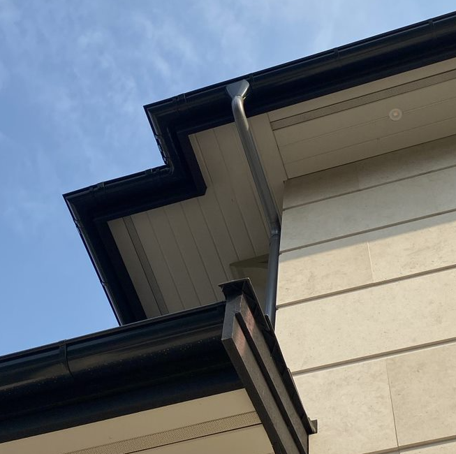Looking up at the roof of a house with a blue sky in the background