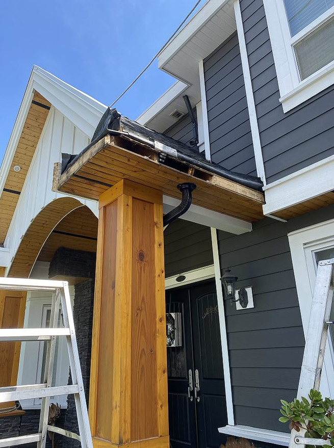 A house with a wooden porch and a ladder in front of it.