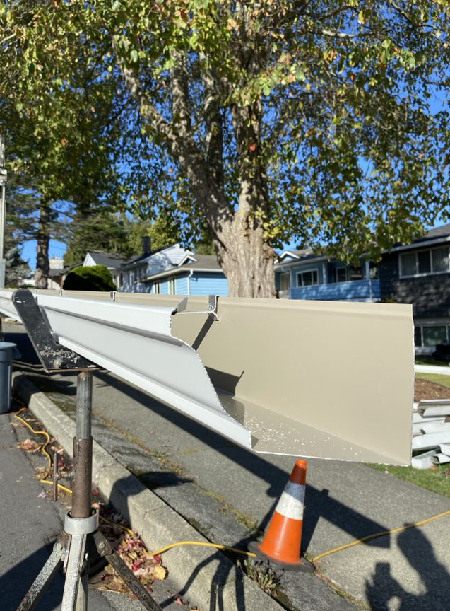 A gutter is sitting on the side of the road next to a tree.