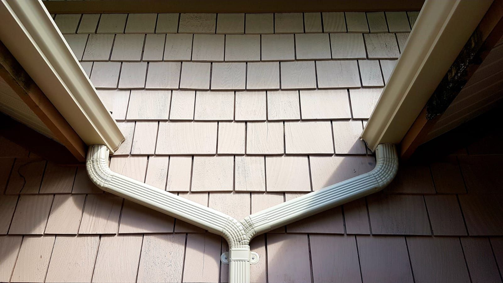 A drainpipe is connected to the roof of a house