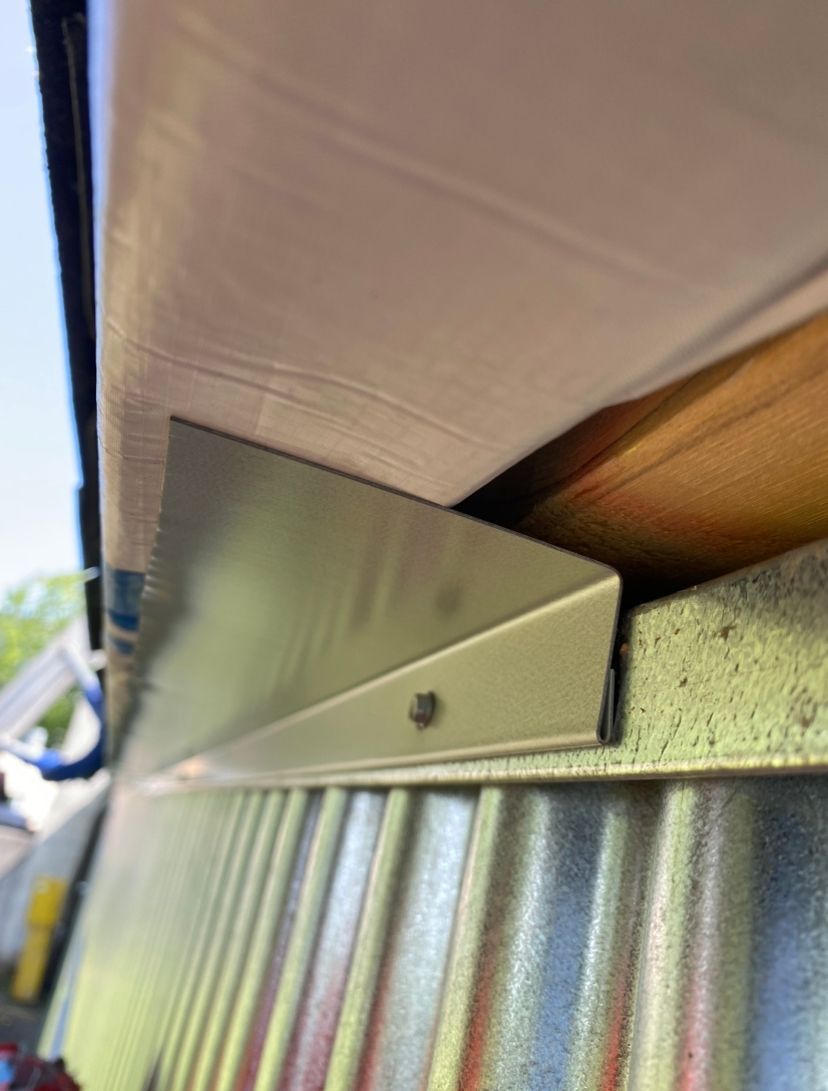 A metal beam is attached to the ceiling of a building.