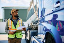Customer and cashier at a salon checkout desk, with a computer monitor and flowers in the background.