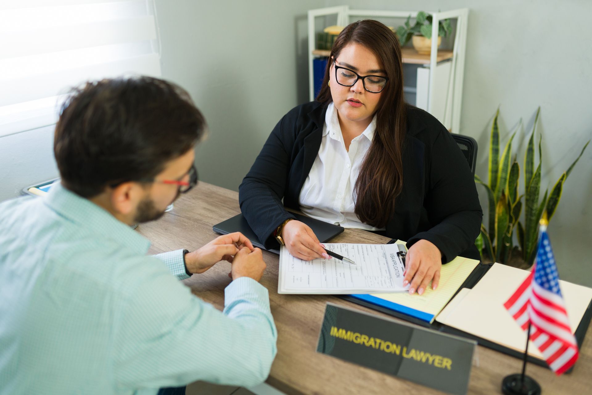 Female immigration lawyer assisting client with legal application process