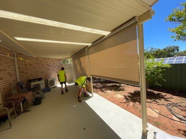 Two Workers Installing Outdoor Roller Blind — Alice Mobile Blinds in Ciccone, NT