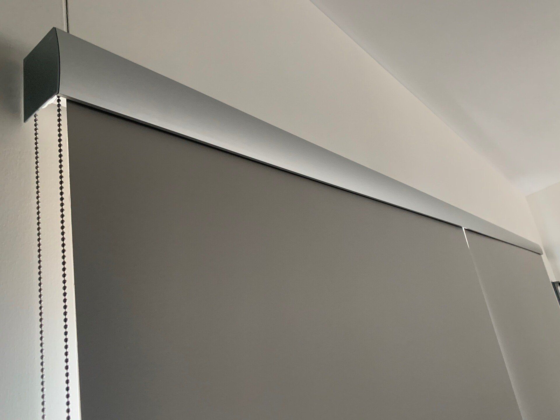 Grey Roller Blind Partially Covering a Window — Alice Mobile Blinds in Ciccone, NT
