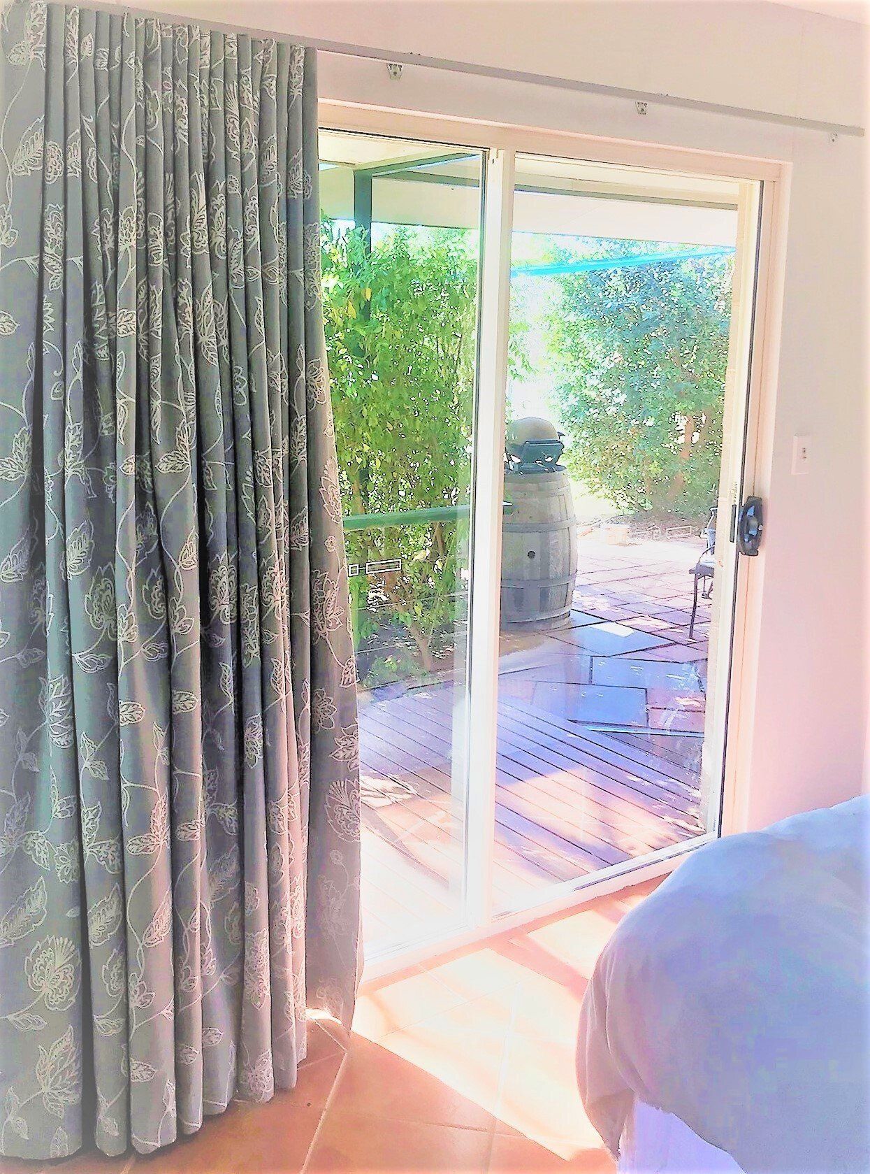 Curtain Next to A Sliding Glass Door Leading to A Patio — Alice Mobile Blinds in Ciccone, NT