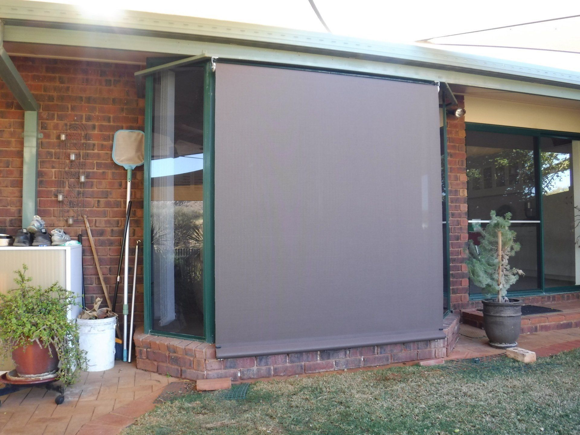 Brown Outdoor Roller Blind Covering a Glass Enclosure — Alice Mobile Blinds in Ciccone, NT