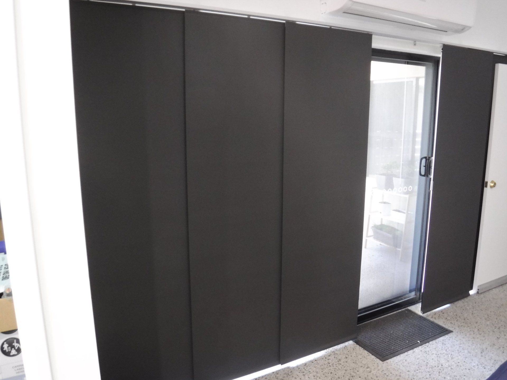Dark Grey Panel Track Blinds Covering a Glass Door — Alice Mobile Blinds in Ciccone, NT