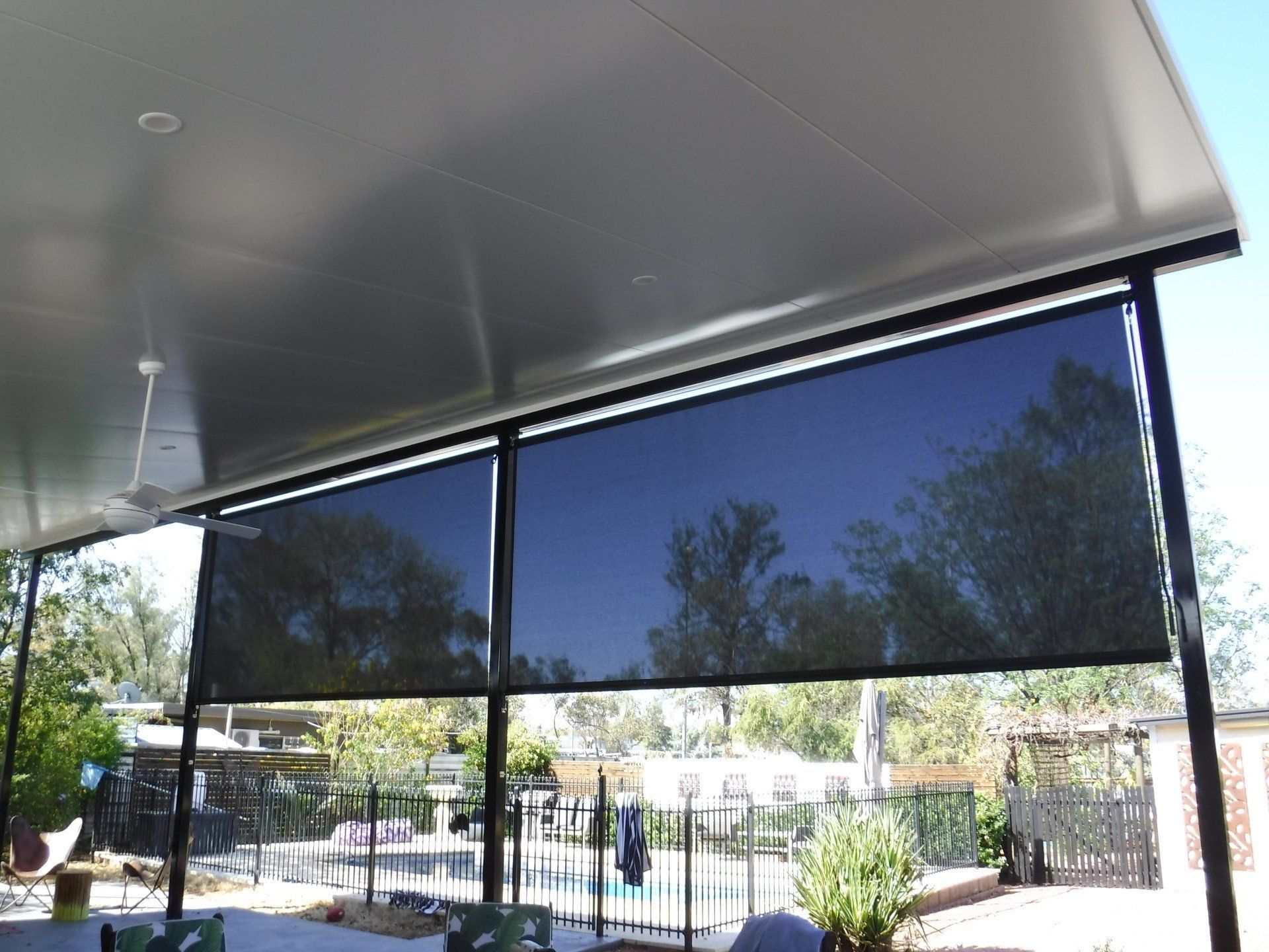 Black Outdoor Roller Shades on A Patio — Alice Mobile Blinds in Ciccone, NT