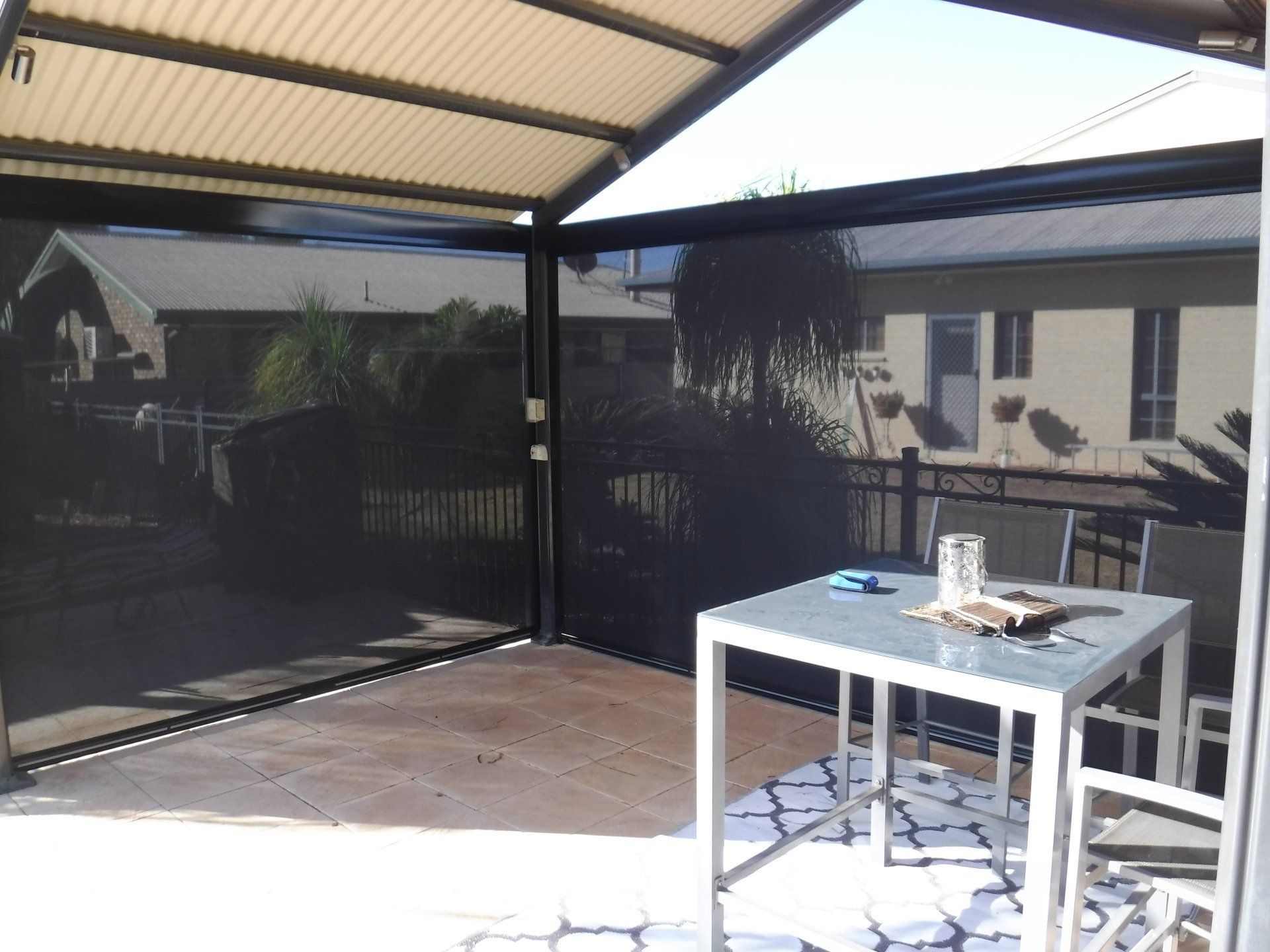 Patio with Shade Screens, Table and Chairs on Tile Floor — Alice Mobile Blinds in Ciccone, NT