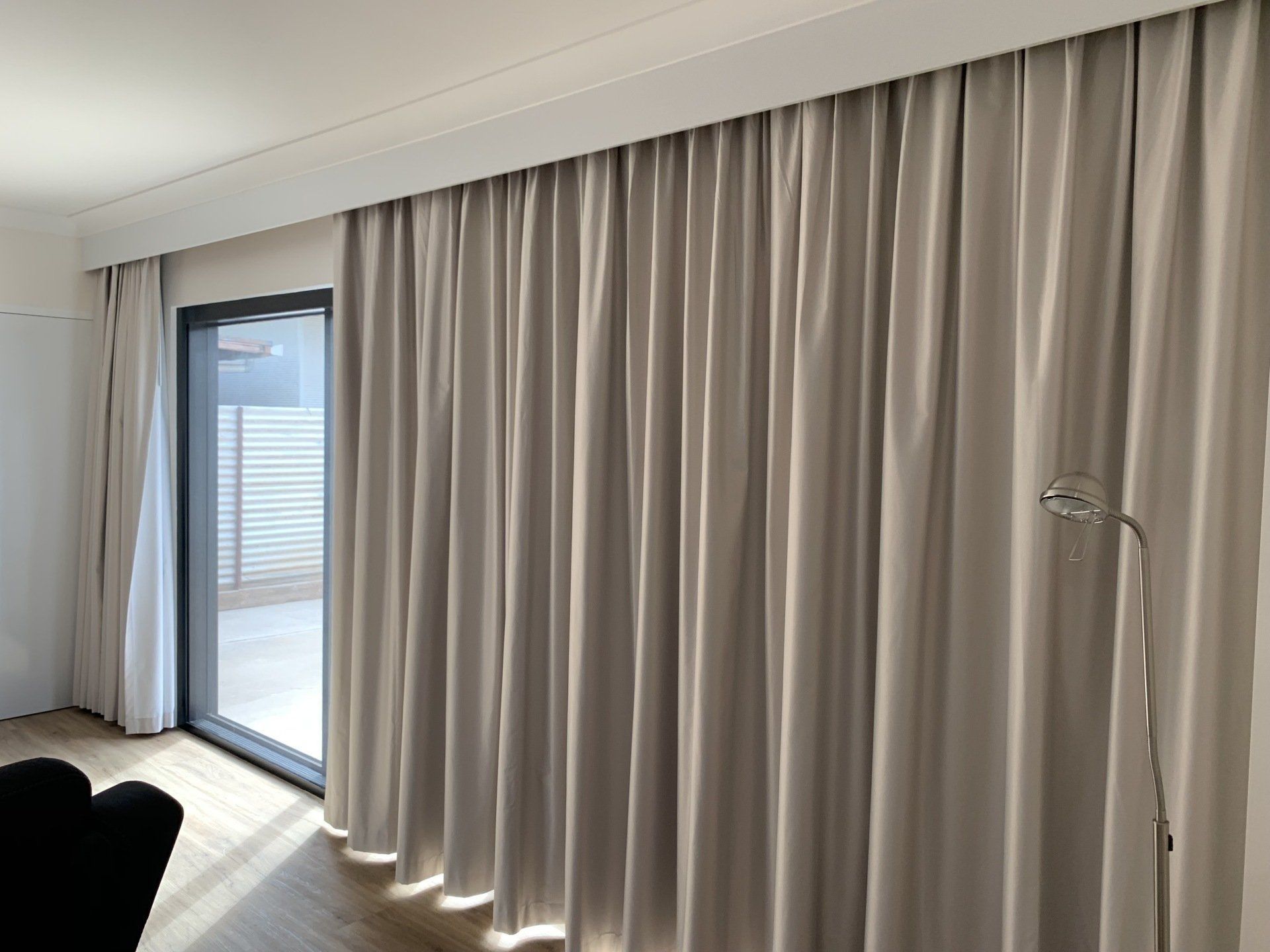 Light Grey Curtains Hang in A Room — Alice Mobile Blinds in Ciccone, NT