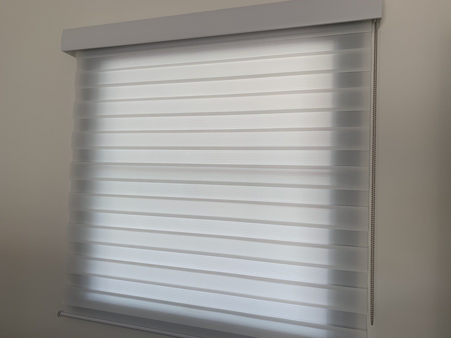 White and Light Grey Layered Window Blinds Covering a Window — Alice Mobile Blinds in Ciccone, NT