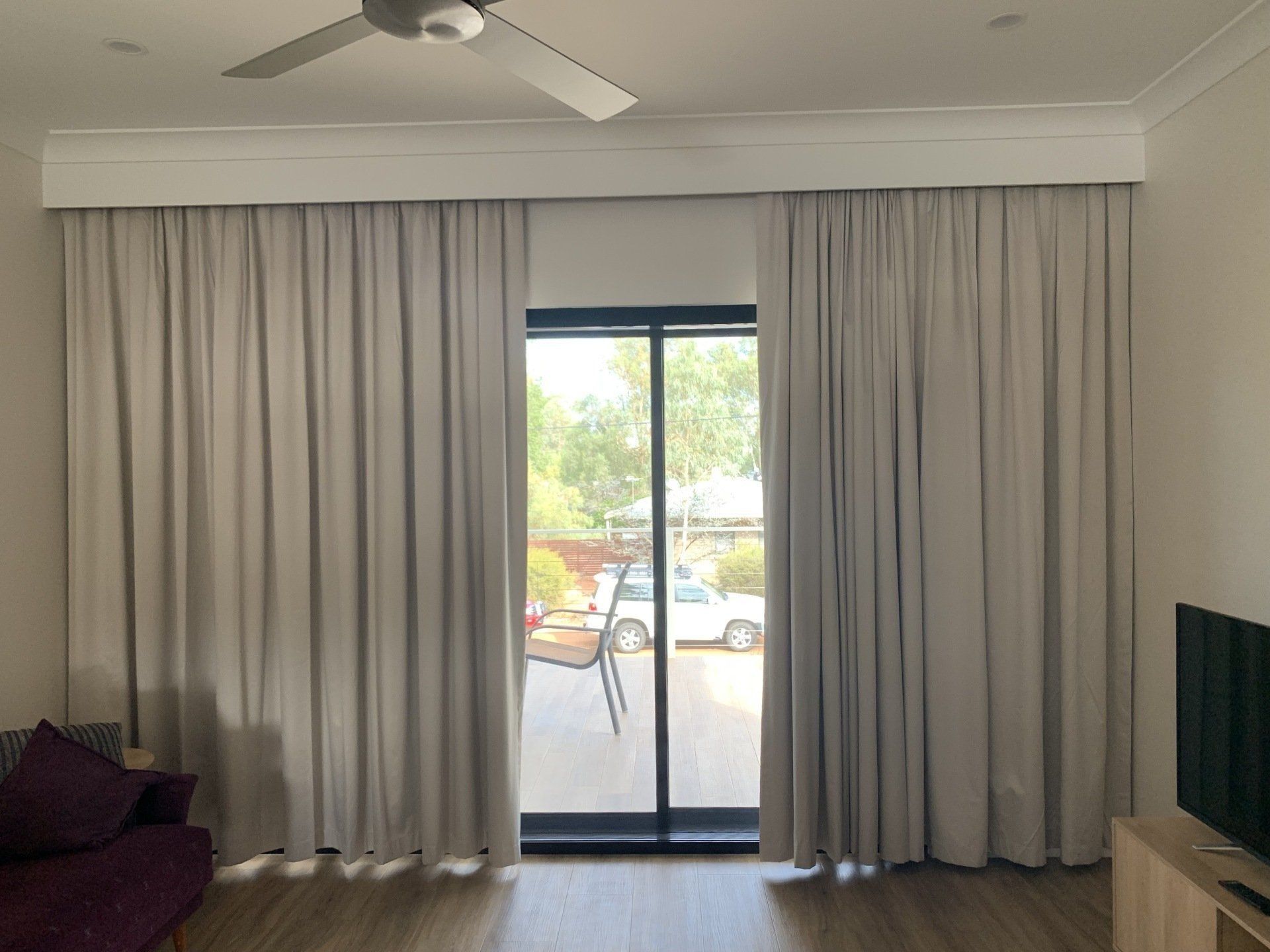 Light Grey Curtains Frame a Sliding Glass Door — Alice Mobile Blinds in Ciccone, NT
