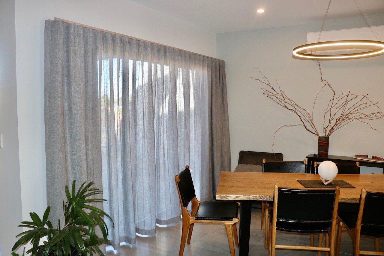 Dining Room with Sheer Grey Curtains and Wooden Table — Alice Mobile Blinds in Ciccone, NT