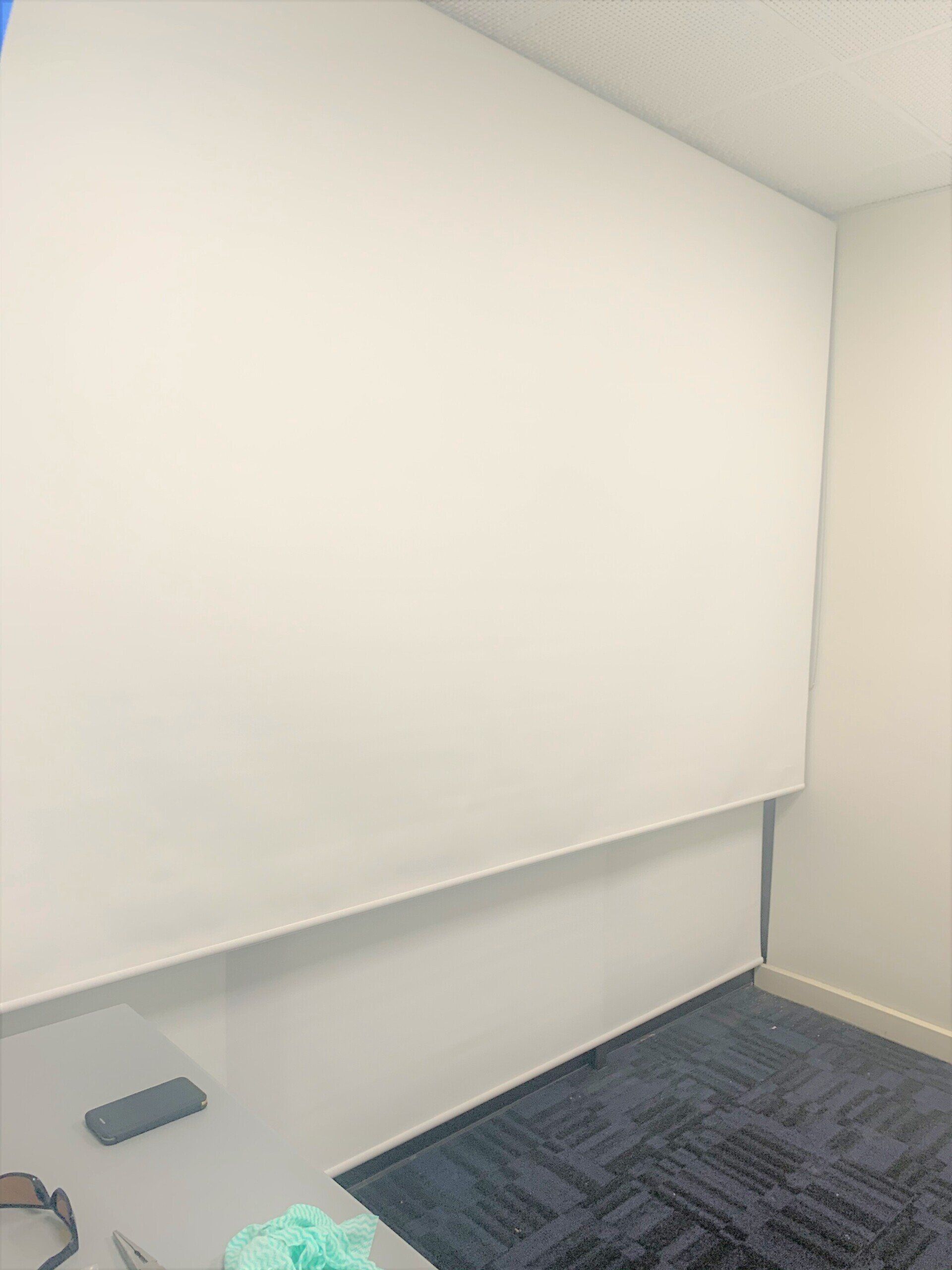 White Wall in A Room with A Blue Carpet and A Grey Table — Alice Mobile Blinds in Ciccone, NT
