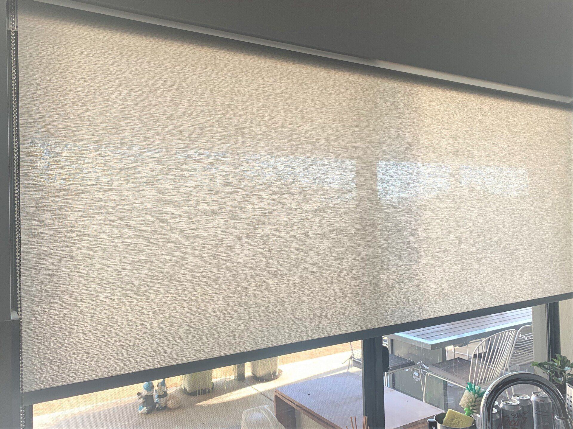 Beige Roller Shade Partially Covering a Window — Alice Mobile Blinds in Ciccone, NT