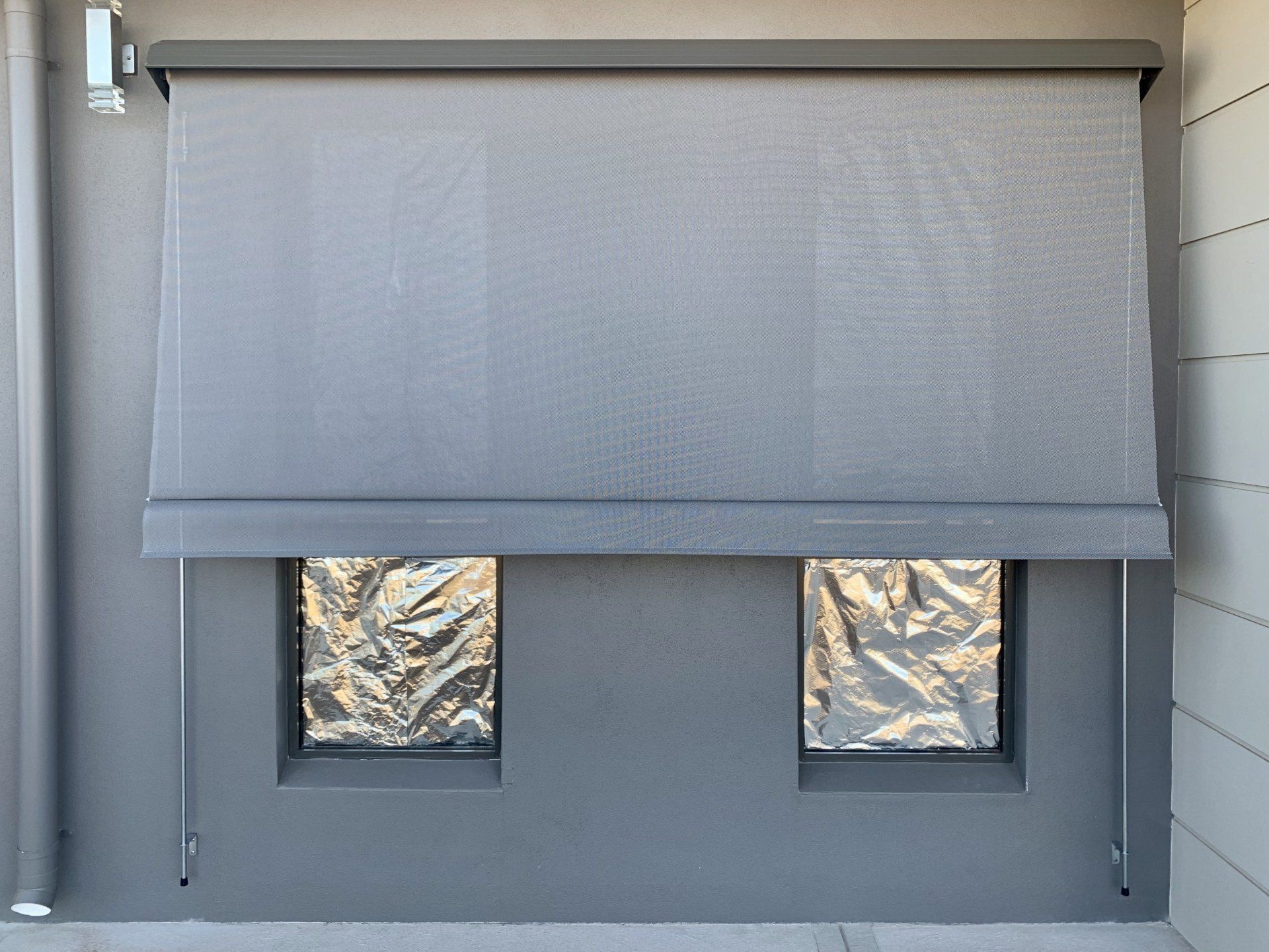Grey Outdoor Roller Shade Partially Lowered Over the Windows — Alice Mobile Blinds in Ciccone, NT