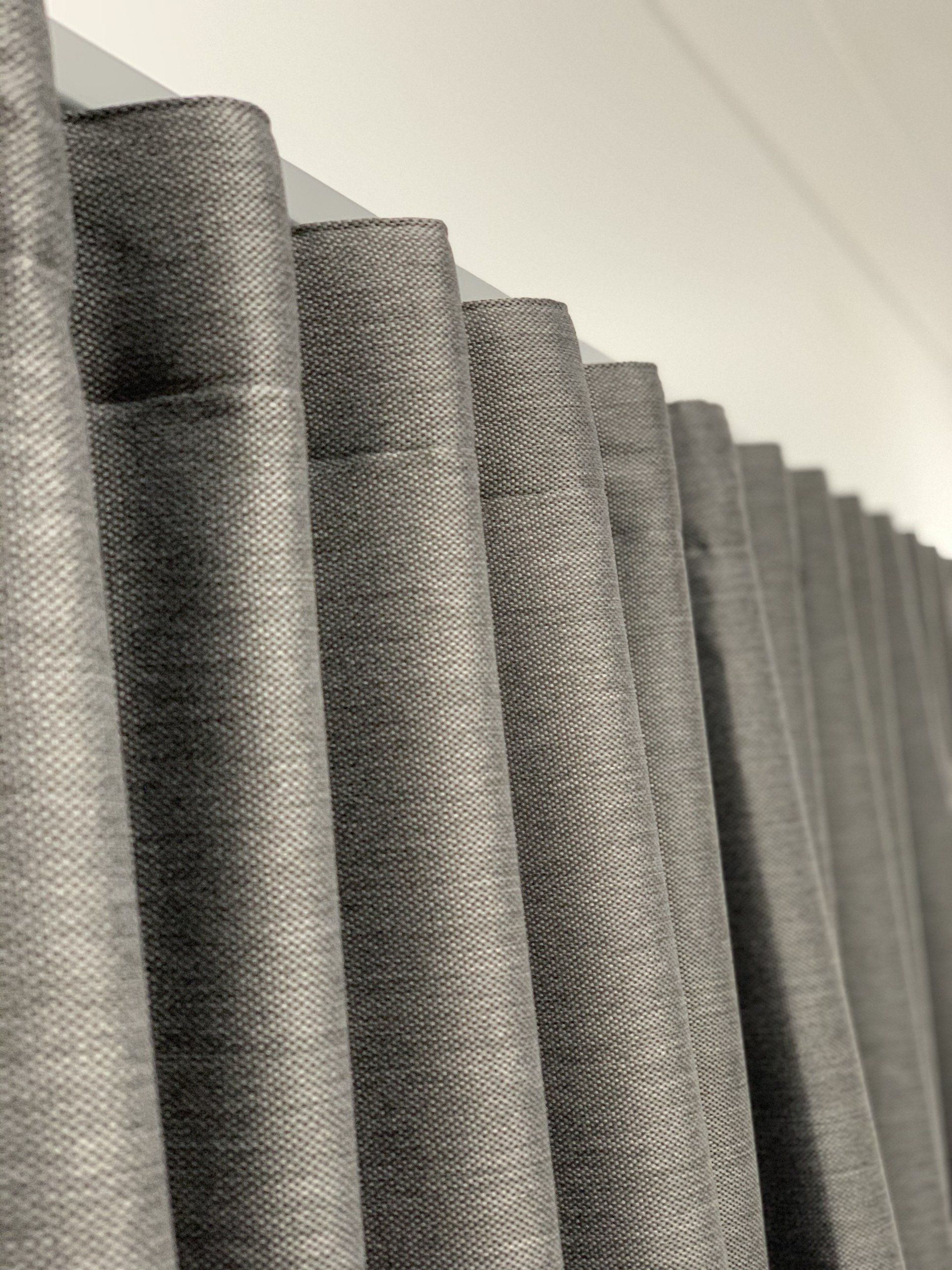 Grey Fabric Curtains Hanging Against a White Wall — Alice Mobile Blinds in Ciccone, NT