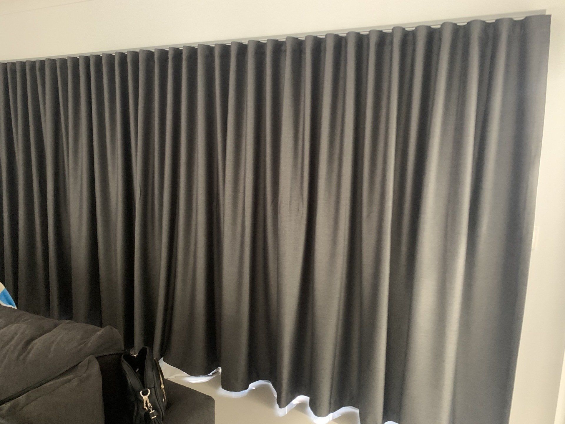 Dark Grey Pleated Curtains Hanging in Front of A Window — Alice Mobile Blinds in Ciccone, NT