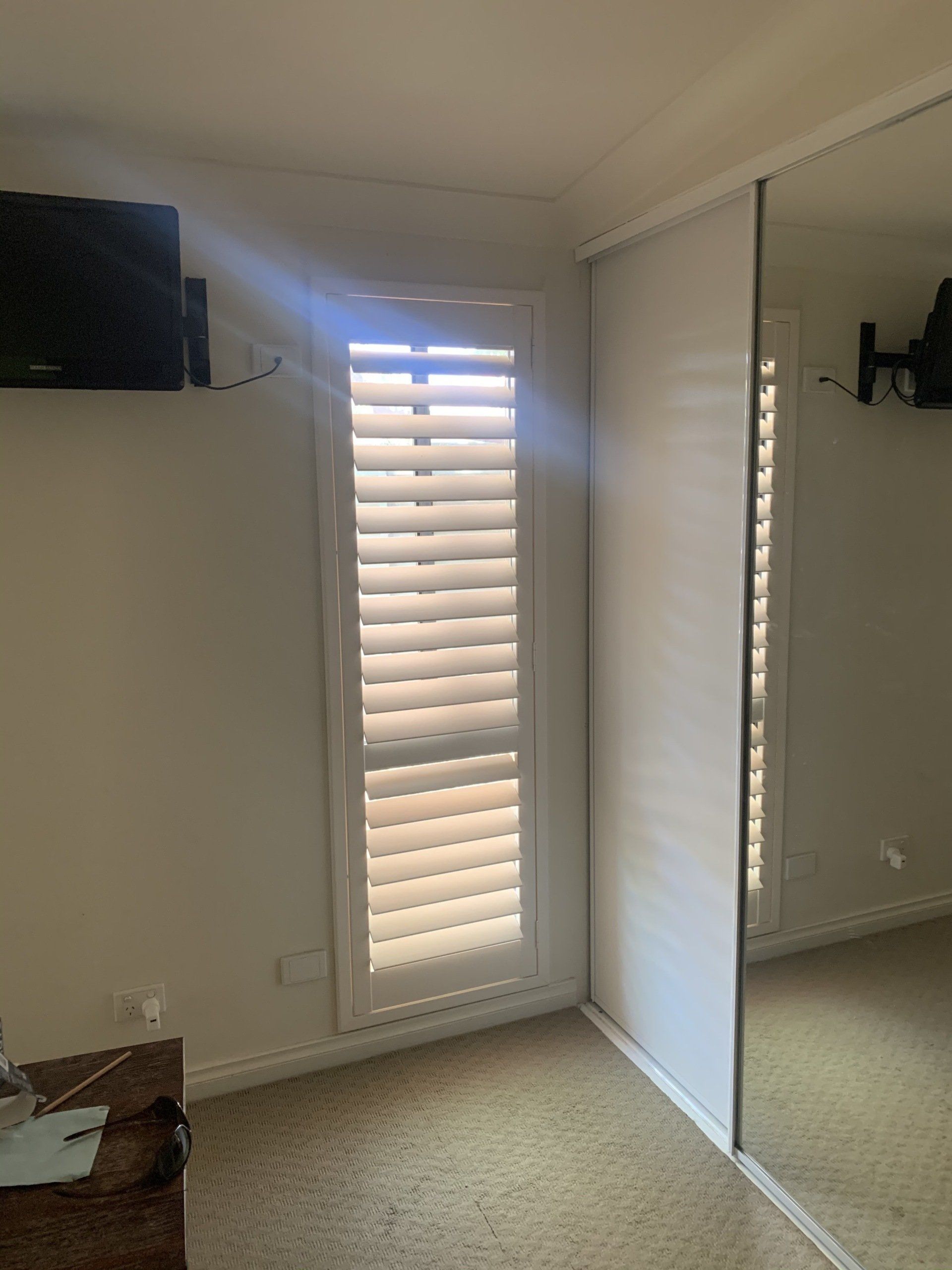 Narrow Window with White Shutters Next to A Mirrored Closet Door — Alice Mobile Blinds in Ciccone, NT