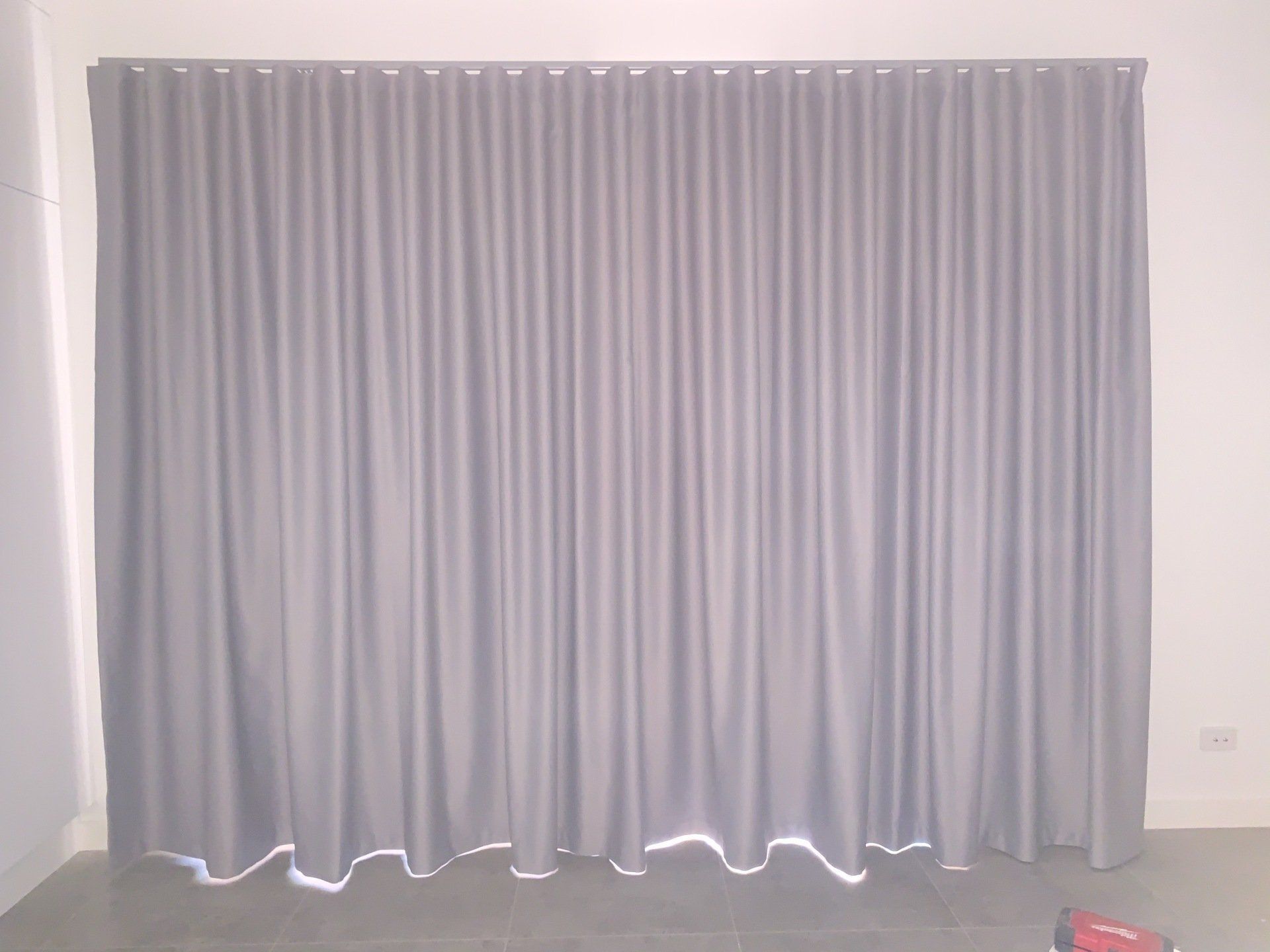 Grey Curtains Hanging in Front of A White Wall — Alice Mobile Blinds in Ciccone, NT
