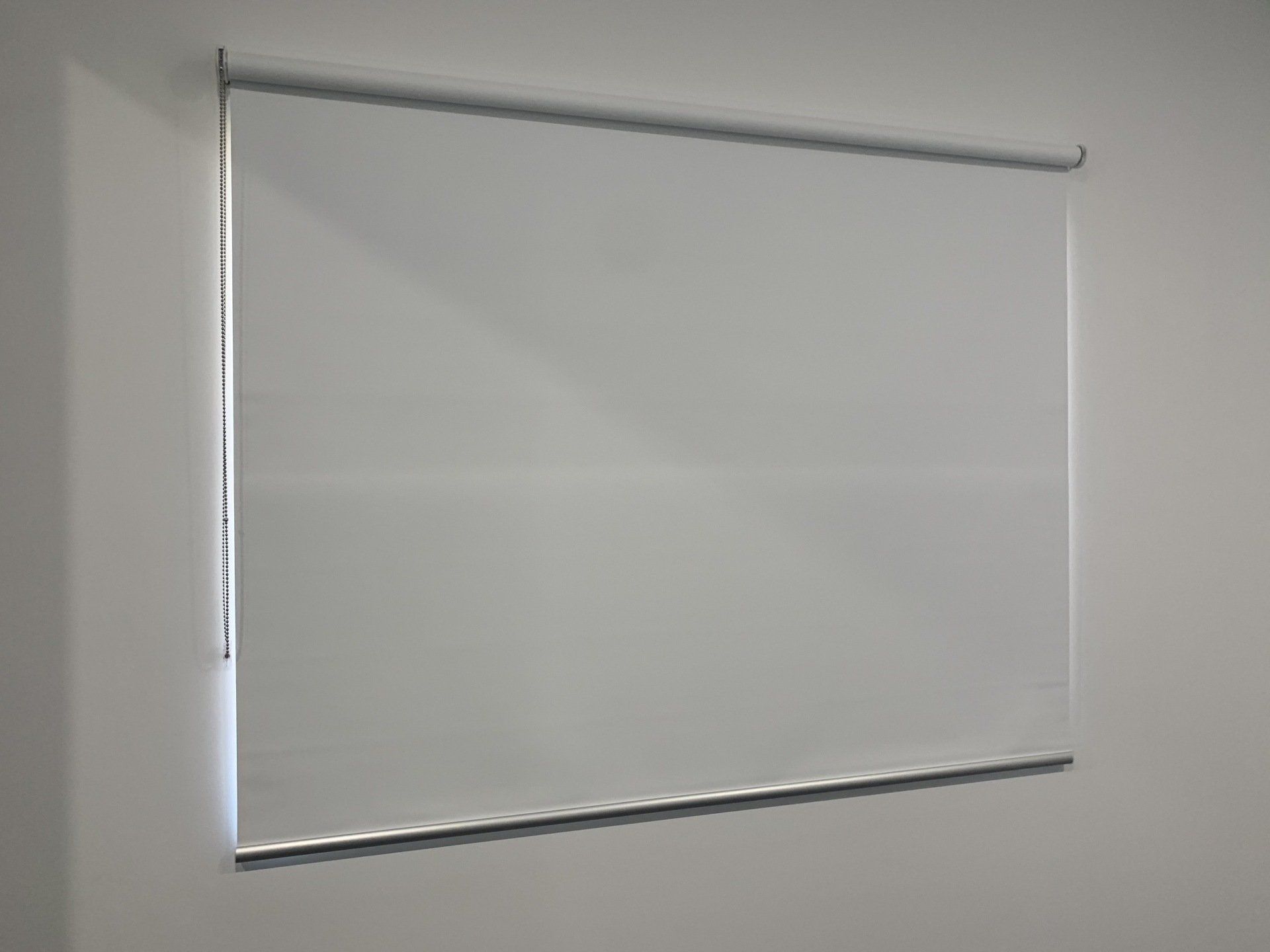 Light Grey Roller Shade on A White Wall — Alice Mobile Blinds in Ciccone, NT