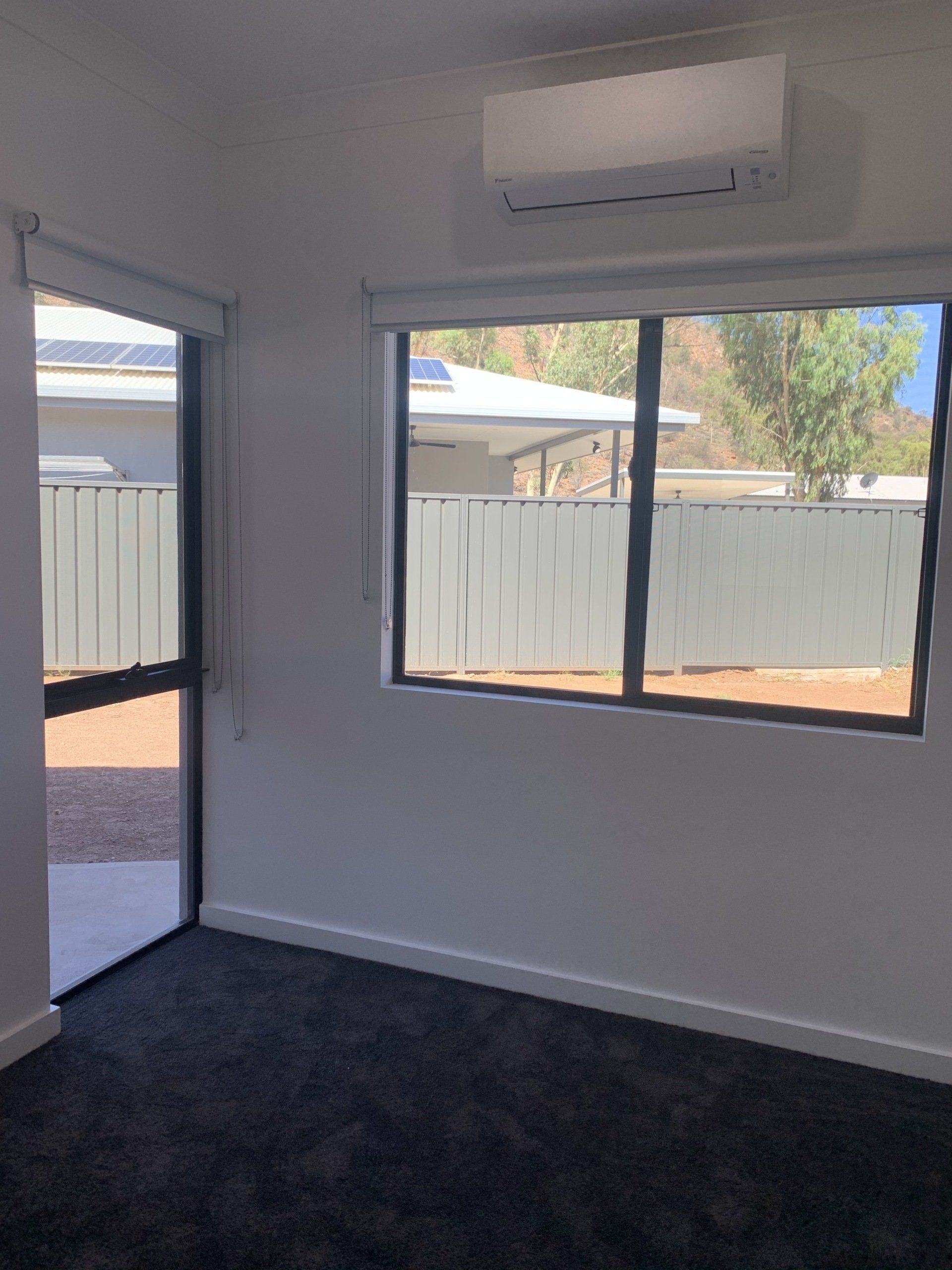 Interior Room with Black Carpet, Window and Door Leading Outside — Alice Mobile Blinds in Ciccone, NT