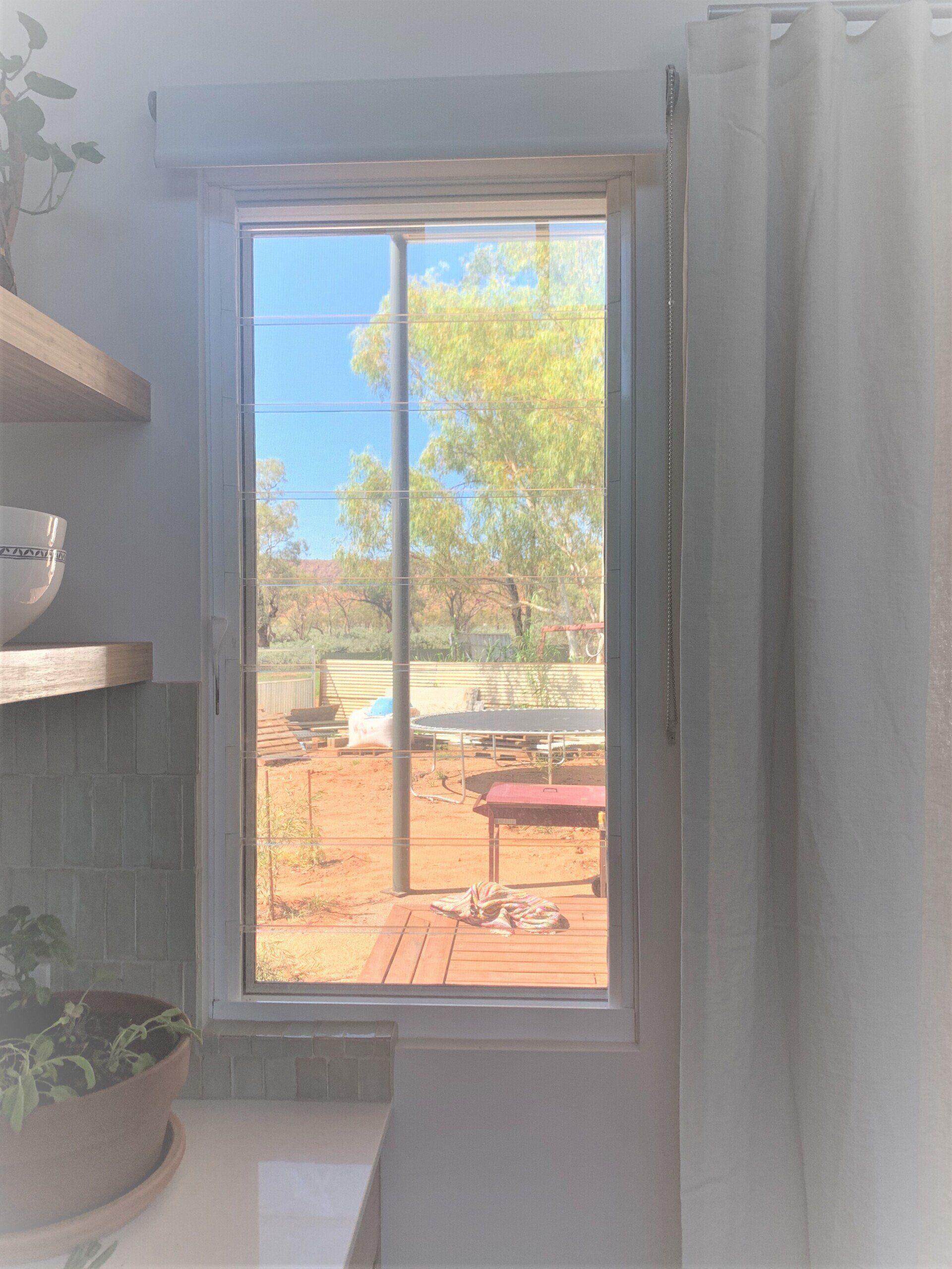 Window with A View of A Backyard with Trees and A Red Bench — Alice Mobile Blinds in Ciccone, NT