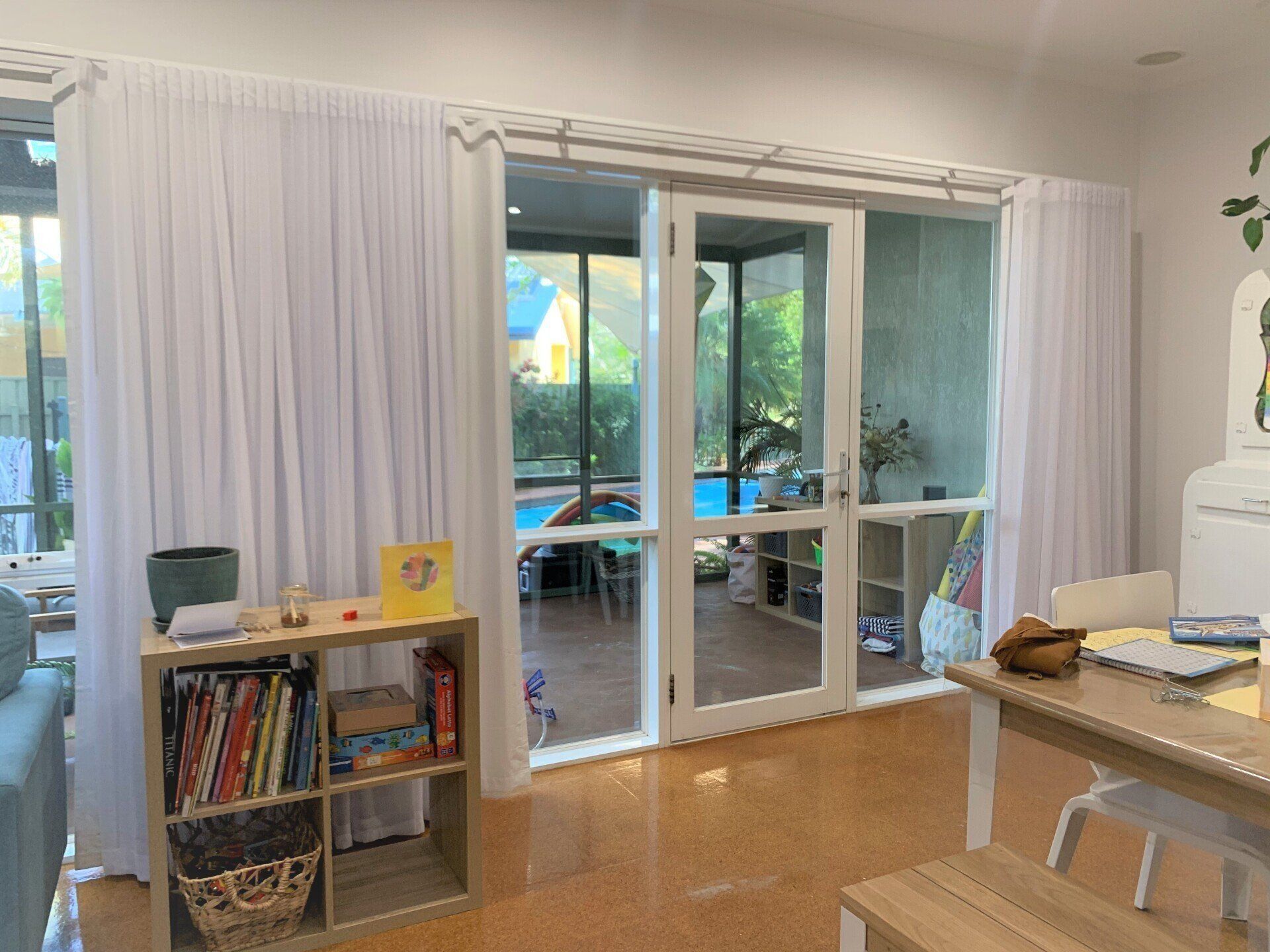 Room with White Curtains Glass Doors Opening to A Pool Area — Alice Mobile Blinds in Ciccone, NT