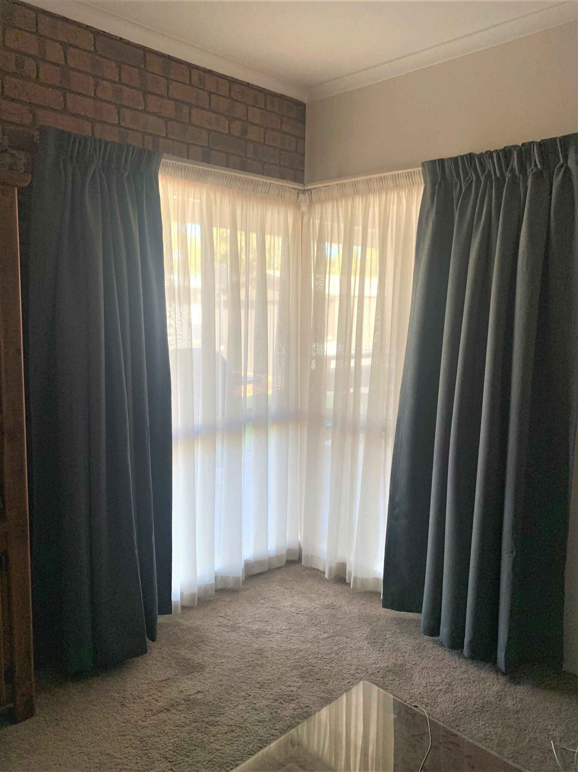 Room with Corner Window Dark Grey Curtains — Alice Mobile Blinds in Ciccone, NT