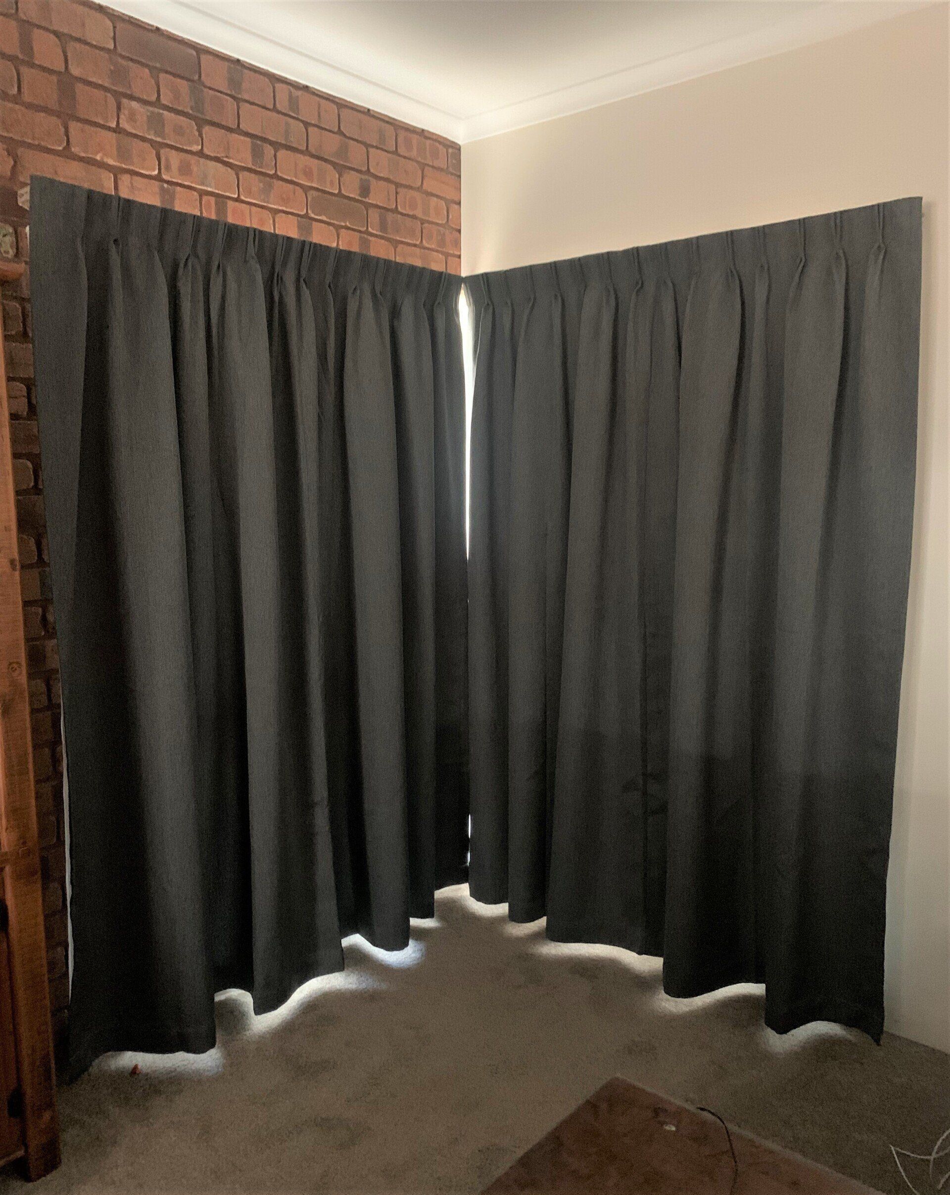 Dark Grey Curtains Hung in A Corner Against Brick — Alice Mobile Blinds in Ciccone, NT