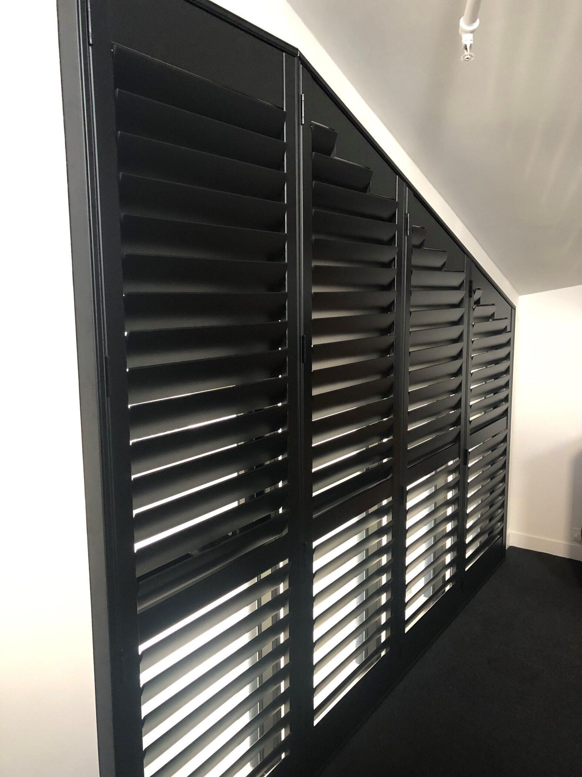 Black Plantation Shutters Covering a Slanted Window — Alice Mobile Blinds in Ciccone, NT