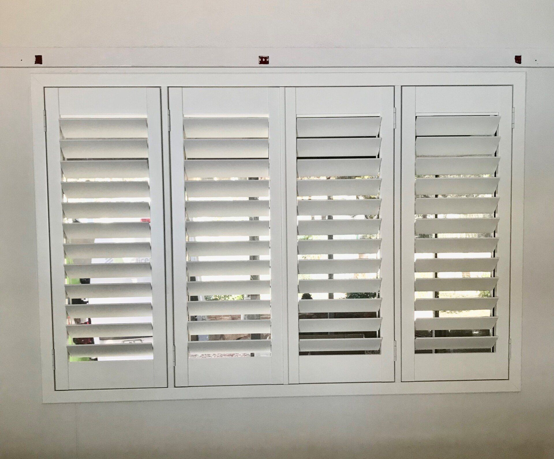 White Shutters, Four Panels with Adjustable Louvers, Mounted on A White Wall — Alice Mobile Blinds in Ciccone, NT