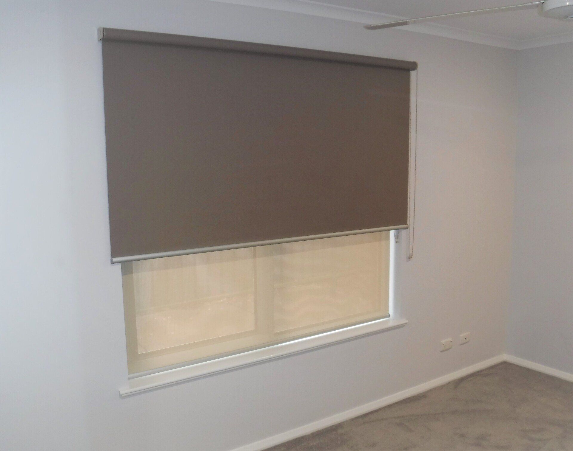 Brown Roller Shade Over a Window in A Room with Light Grey Walls — Alice Mobile Blinds in Ciccone, NT