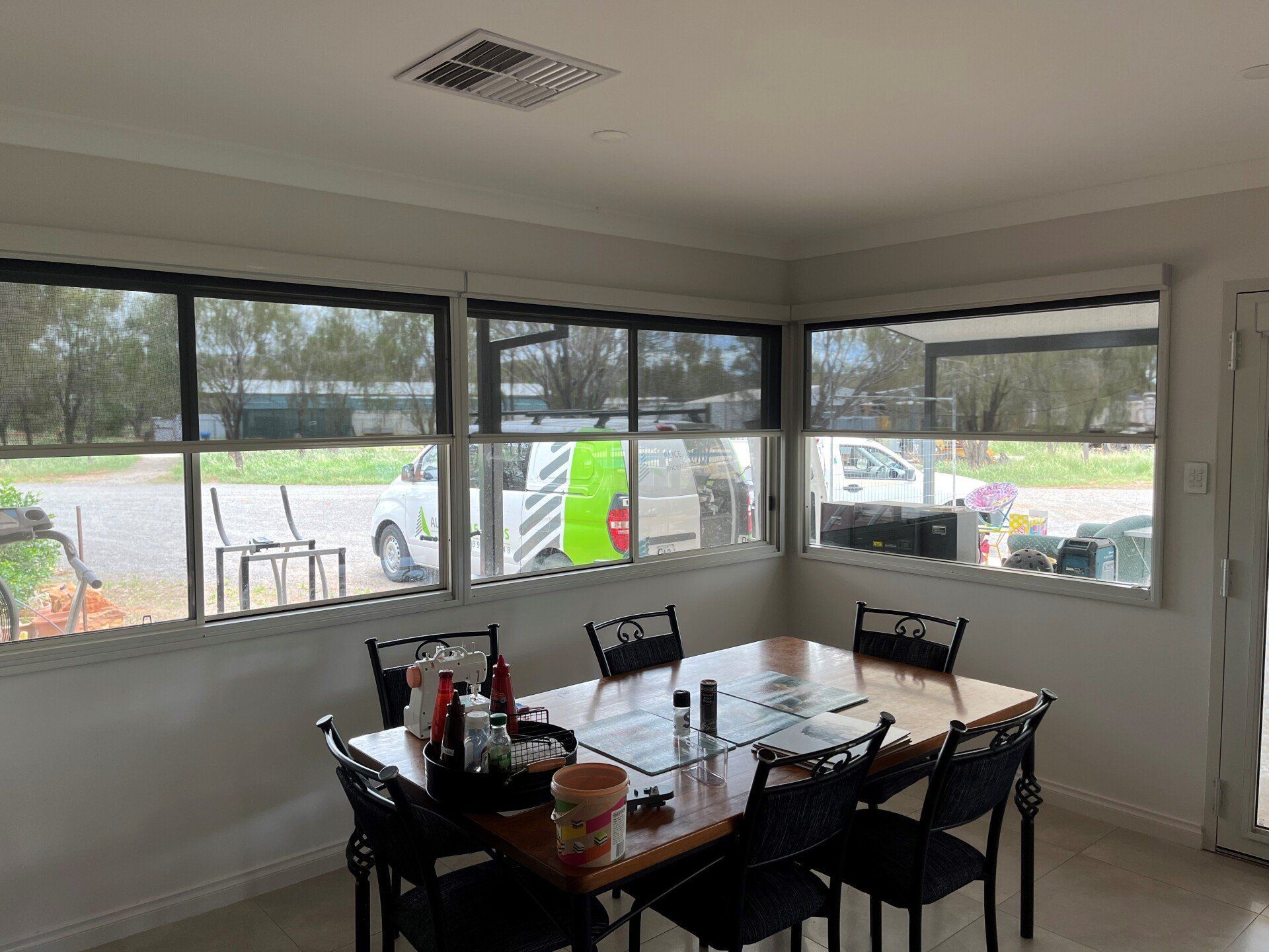 Dining Room with Table and Chairs Near Corner Windows — Alice Mobile Blinds in Ciccone, NT