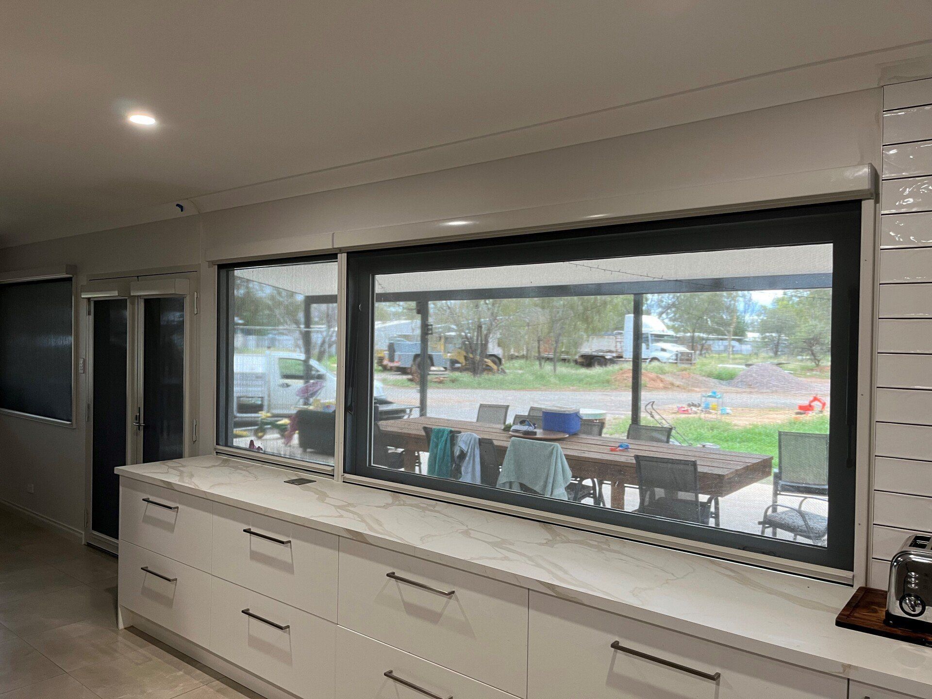 Modern Kitchen with Long Countertop and Large Windows — Alice Mobile Blinds in Ciccone, NT