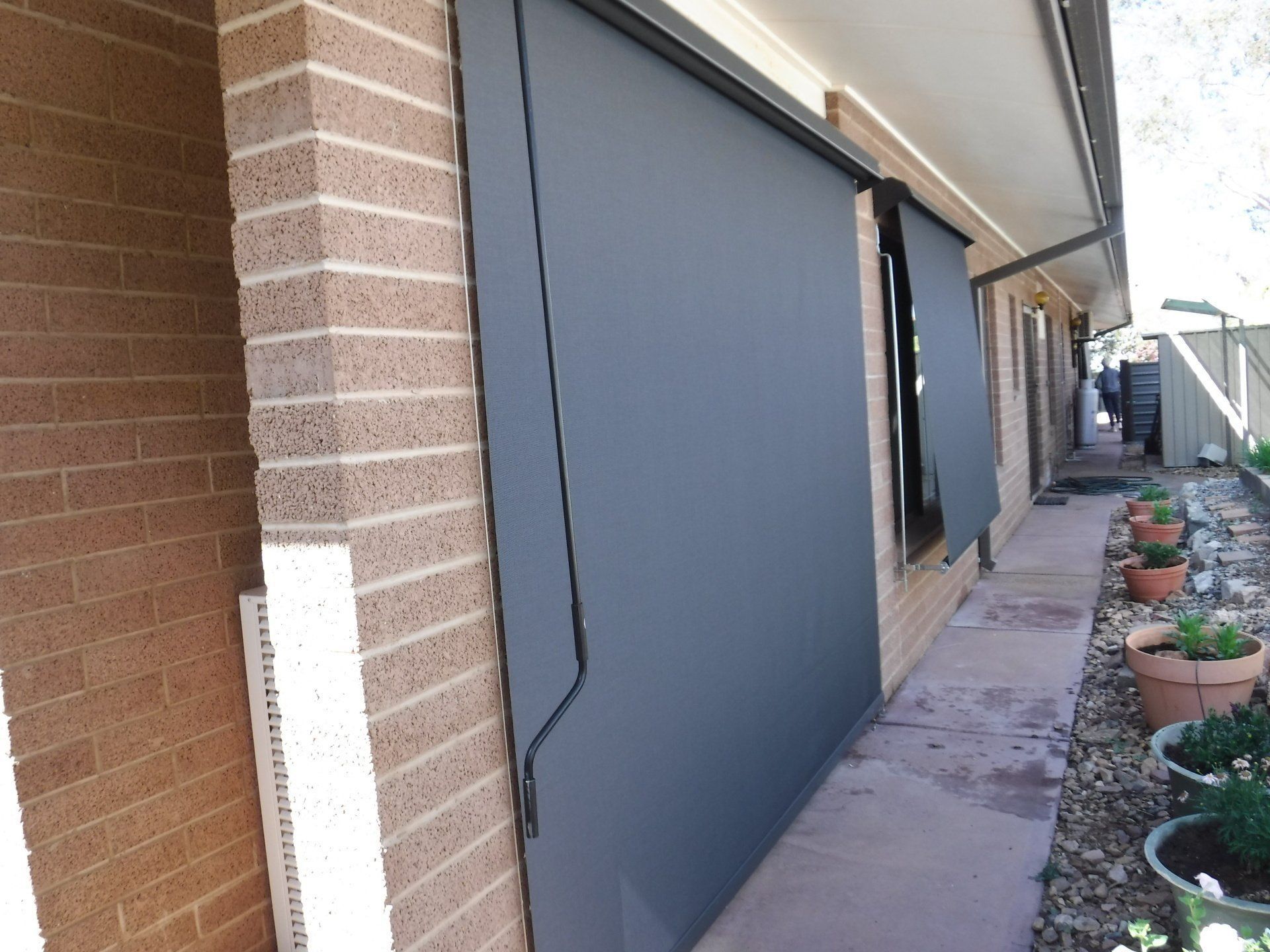 Exterior View of House with Dark Grey Retractable Sun Shades — Alice Mobile Blinds in Ciccone, NT