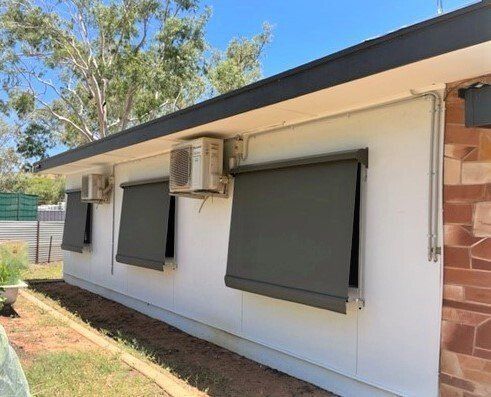 White Building with Grey Blinds and AC Units — Alice Mobile Blinds in Ciccone, NT