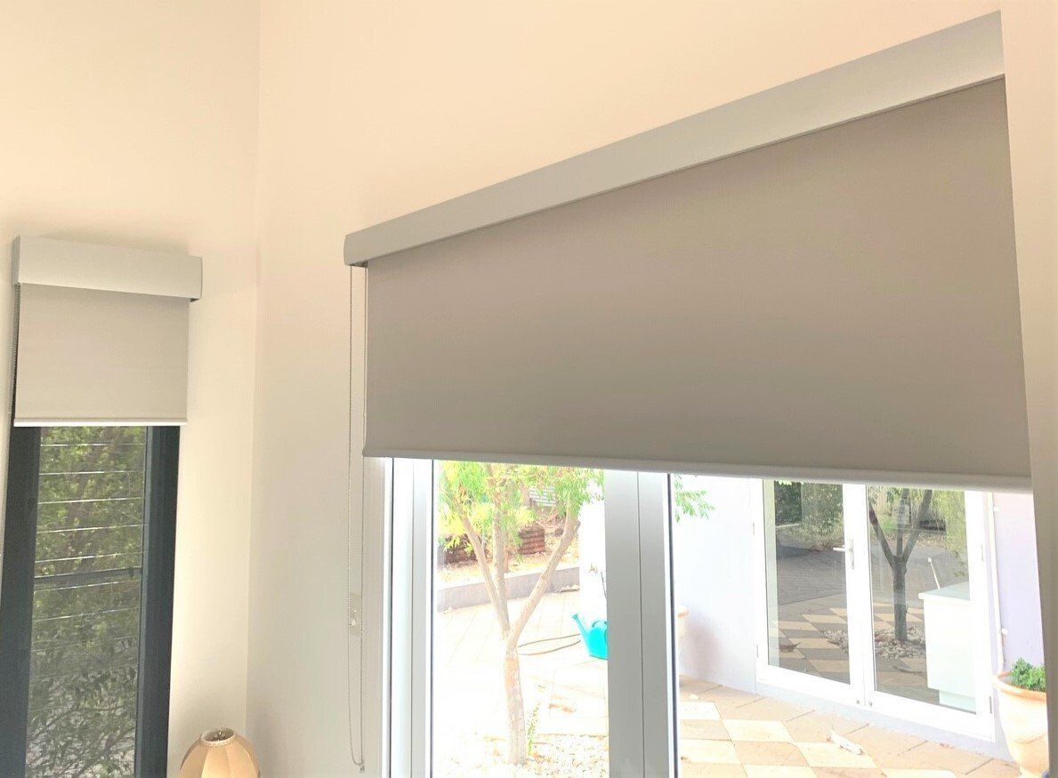 Grey Roller Blinds Covering Windows in A Bright Room — Alice Mobile Blinds in Ciccone, NT