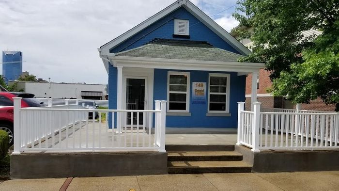 A blue house with a white porch and stairs